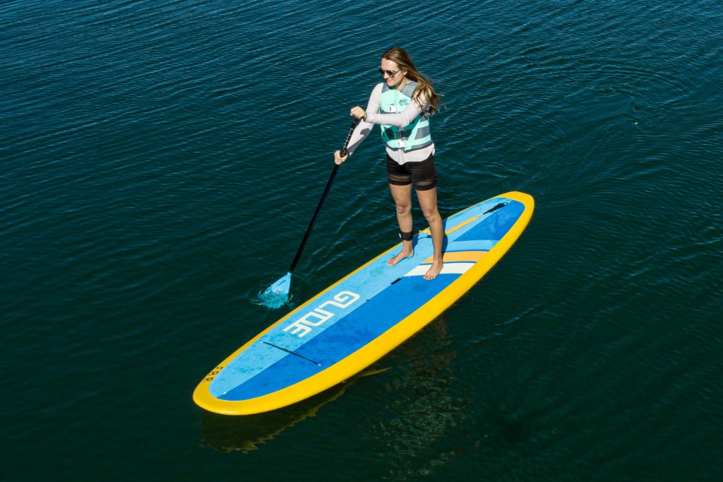 blonde woman on standup paddle boat