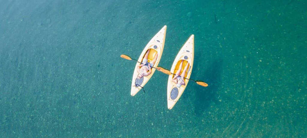 two kayakers paddling in ocean