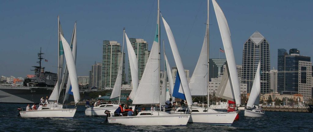 group of Sailboats cruising in front of San Diego city