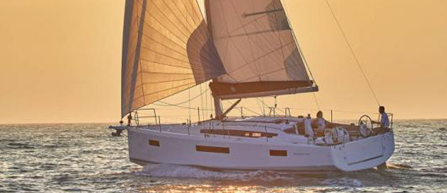 Sailboat at sea during sunset with people onboard.