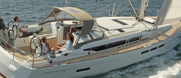 People enjoying a sunny day on a sailing yacht at sea.