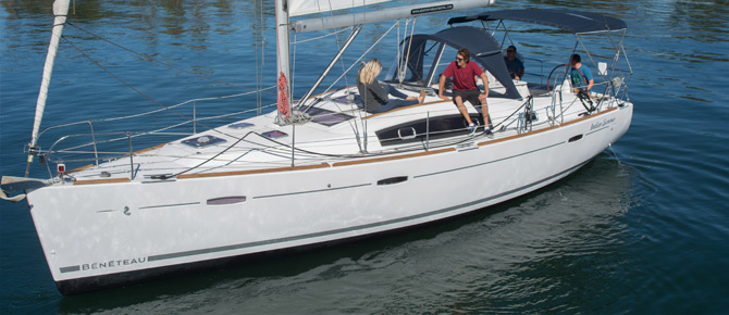 A sailboat with people aboard cruising on calm water.