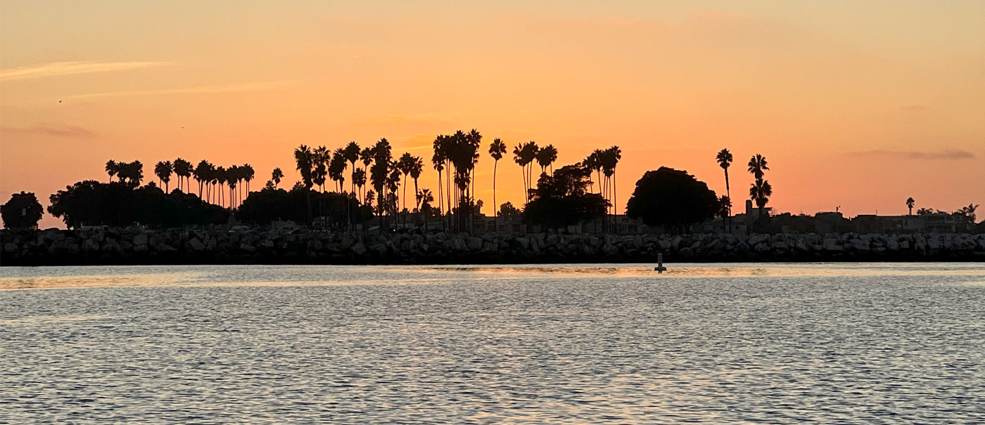 Serene sunset at San Diego Harbor, with Seaforth Boat Rentals' boats gently bobbing in the water under the glowing sky.