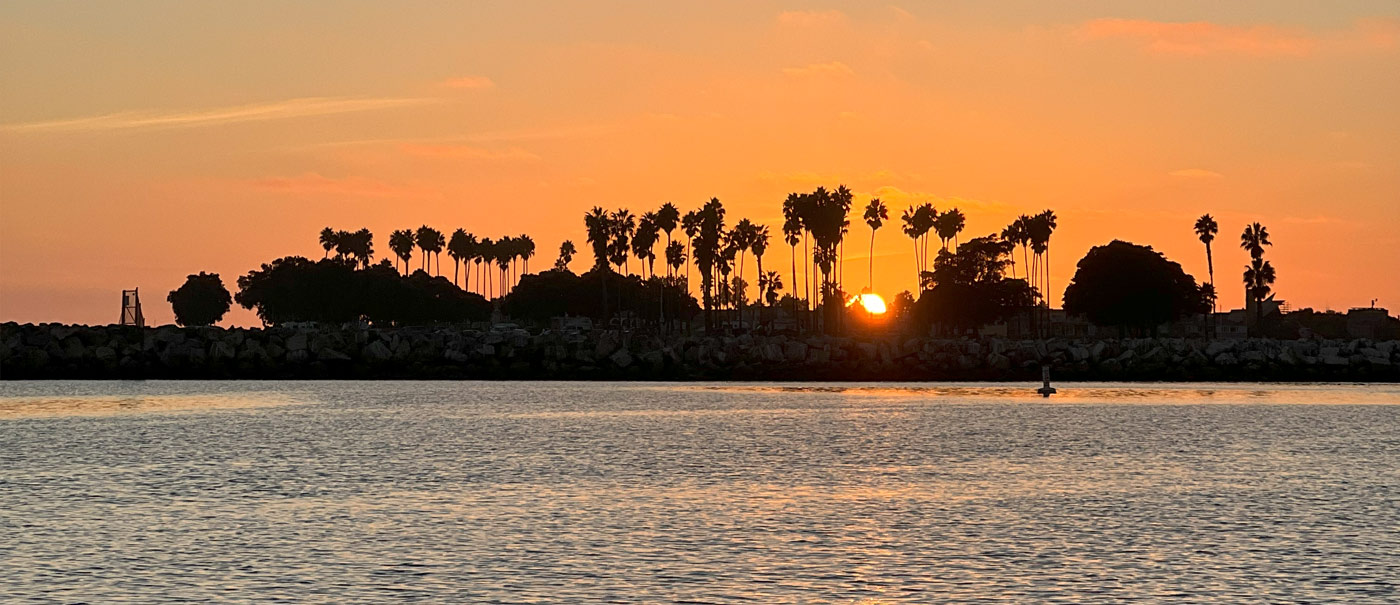 Vibrant sunset at San Diego Harbor, with boats from Seaforth Boat Rentals silhouetted against the colorful sky.