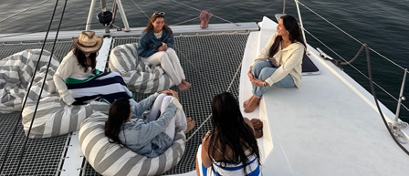 Four women relax on a boat deck, enjoying their time with Seaforth Boat Rentals.