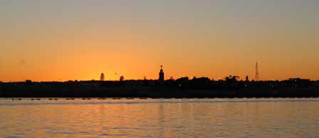 The sun sets over Cairo, casting a warm glow on the city skyline.