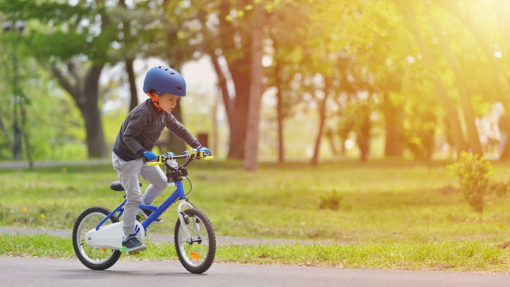 Image of a young boy biking on a road, capturing a moment of joy and adventure near Seaforth Boat Rentals.