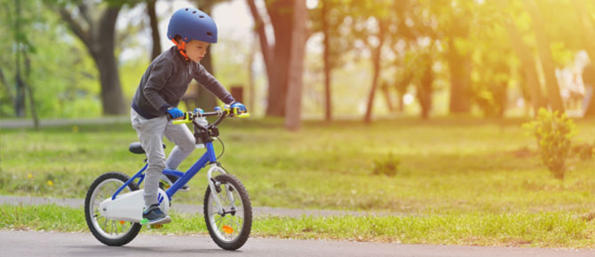 Image of a young boy biking on a road, capturing a moment of joy and adventure near Seaforth Boat Rentals.