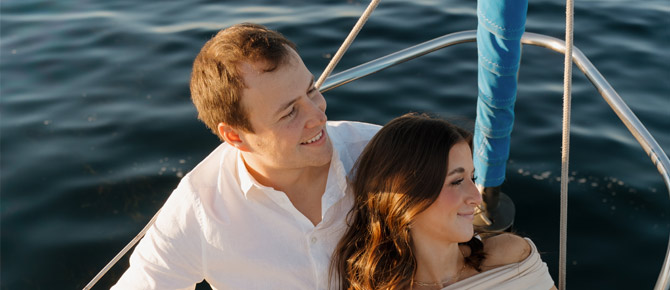 Joyful couple enjoying a romantic bay cruise after their proposal on a yacht,