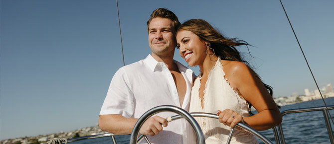Smiling couple celebrating their romantic yacht engagement on a scenic bay cruise,
